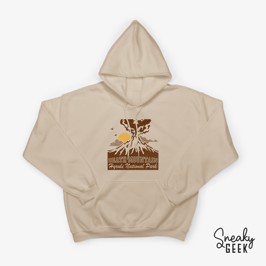 A beige hoodie featuring a design inspired by the Legend of Zelda. The design shows Death Mountain with a stylized eruption and the text 'Death Mountain Hyrule National Park' below it.